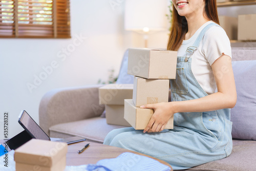 Online merchant concept, Female entrepreneur is holding parcel boxes to prepare sending to customer