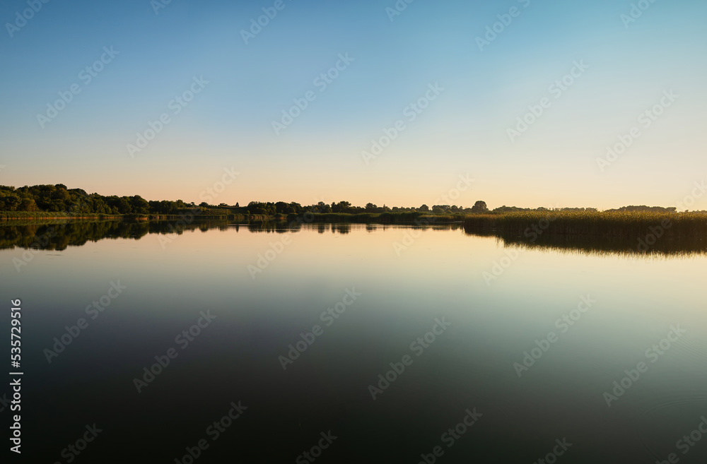 Summer sunset over a river with a blue sky in the background