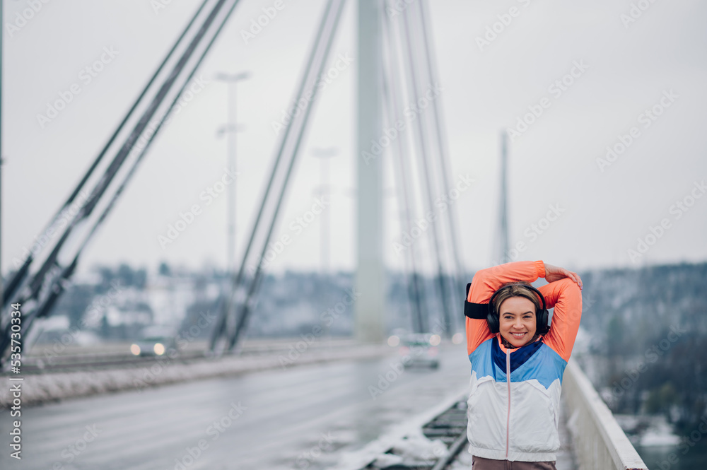 Woman stretching before running on the bridge at winter and snow. Woman stretching before running on the bridge at winter and snow.