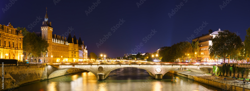Pont au Change bridge near The Conciergerie palace and prison by the Seine river night, Paris. France