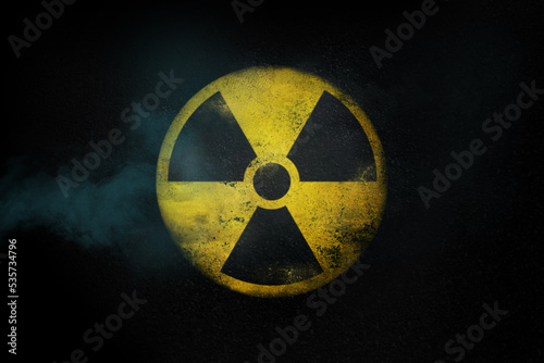 Vászonkép Nuclear energy radioactive round yellow symbol on asphalt texture