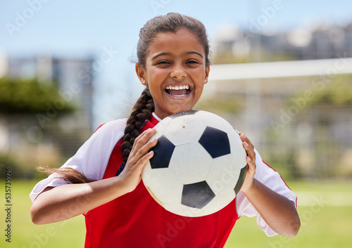 Soccer, sports and happy Indian girl athlete holding a sport ball on a school field. Portrait of fitness, football and exercise of a child smile excited about training, workout and game motivation © Nina Lawrenson/peopleimages.com