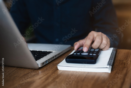 Hand busineaaman doing finances and calculate on desk about cost at office.