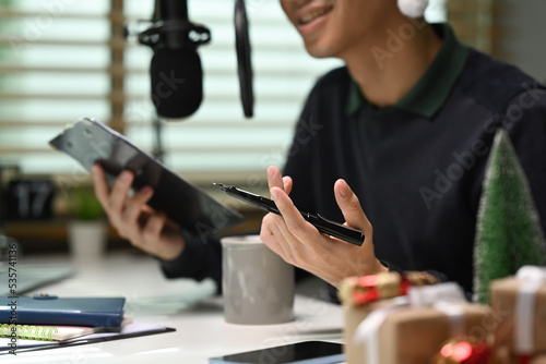 Image of radio host using microphone and laptop to recording podcast in home studio. Radio  podcasts and technology concept