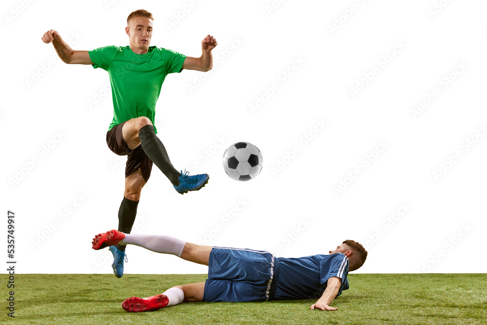 Soccer football players tackling for the ball on grass flooring over white background. Concept of sport, action, competition, football match