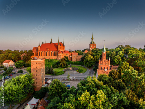 Great view of the beautiful city of Frombork located in Warmia, Poland. Cathedral Hill among trees at sunset.