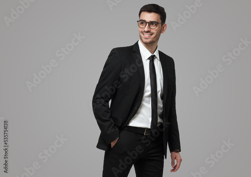 Man in formal clothes looking backwards through glasses, moving as if hurrying to business meeting photo