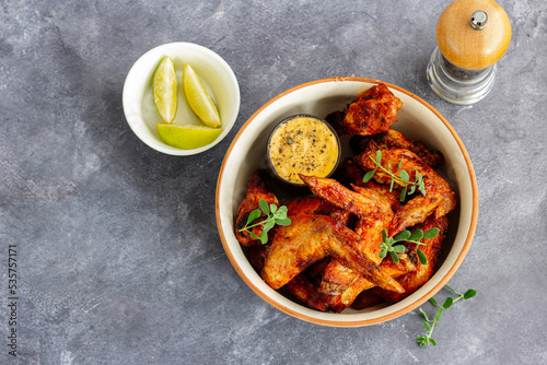 Chicken Wings in a Bowl with Lemon and Sauce Garnished with Fresh Herb Top Down Photo