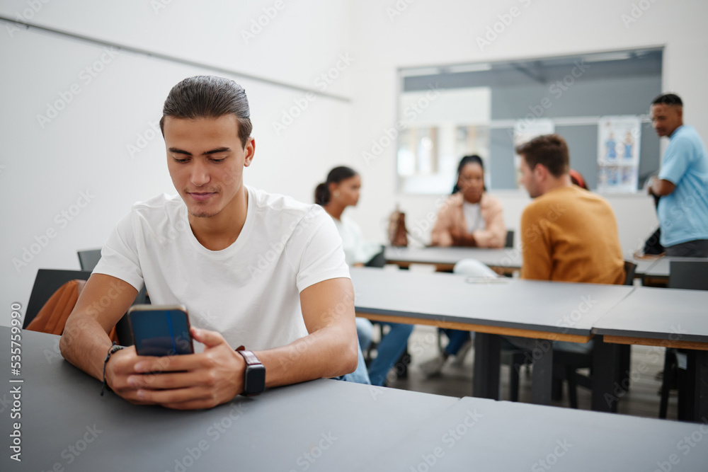 University man and social media on smartphone in lecture auditorium lesson for internet break. Distracted college student busy with phone text communication on online app in education campus.