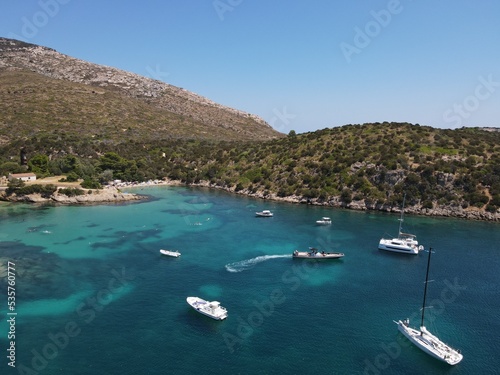 Aerial view of Cala Moresca and Figarolo Island in Golfo Aranci, north Sardinia. Birds eye from above of yacht, boats, crystalline and turquoise water. Tavolara Island in the background, Sardegna. © AerialDronePics