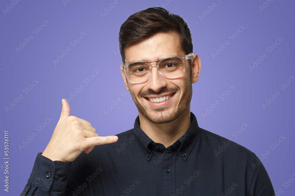 Fototapeta premium Guy isolated on purple background, showing gesture as if asking to dial him, looking confident