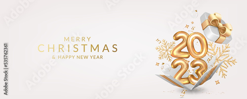 Christmas and New Year 2023 greeting card with open gift box with numbers, balls, gift boxes, confetti, ribbons and snowflakes.	