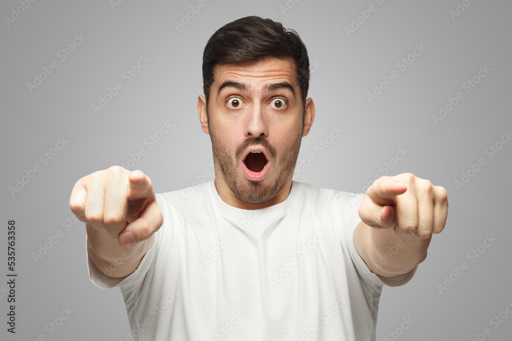 Male pointing at camera with both hands with amazed and shocked face Male pointing at camera with both hands with amazed and shocked face