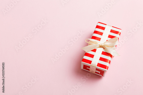 Wrapped christmas or other holiday handmade present in paper with colored ribbon. Present box, decoration of gift on table, top view with copy space © sosiukin