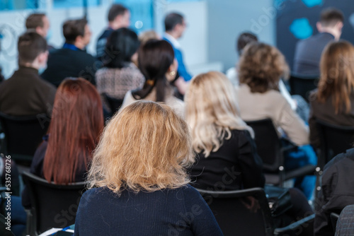 Woman in crowded auditorium during seminar