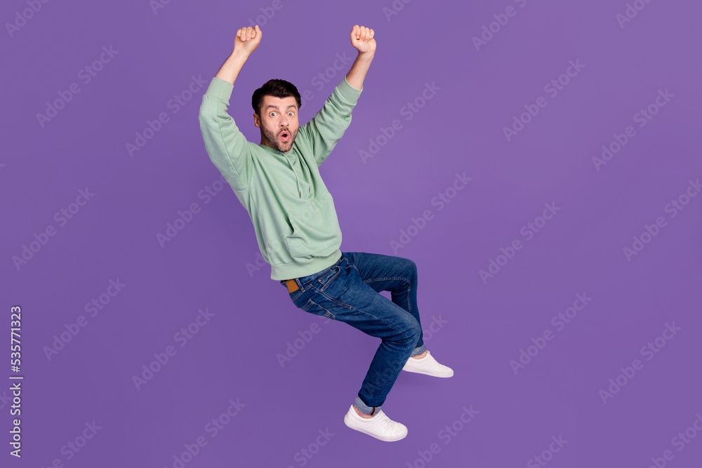 Full length photo of nice young man hang horizontal bar bus handrail dressed stylish khaki outfit isolated on purple color background Full length photo of nice young man hang horizontal bar bus handrail dressed stylish khaki outfit isolated on purple color background