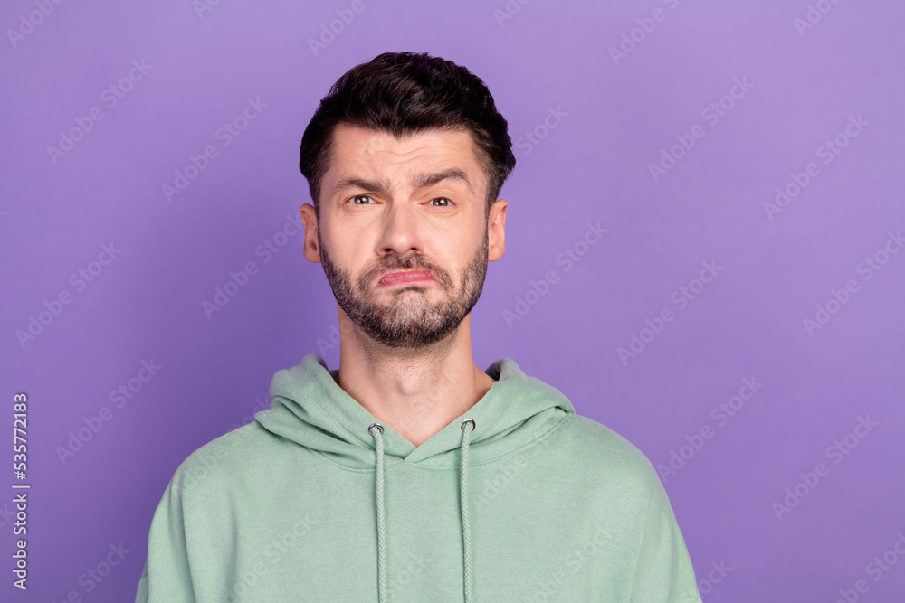 Closeup photo of young sad unhappy bearded man brunet pouted lips problems bored his work suspicious isolated on bright violet color background Closeup photo of young sad unhappy bearded man brunet pouted lips problems bored his work suspicious isolated on bright violet color background