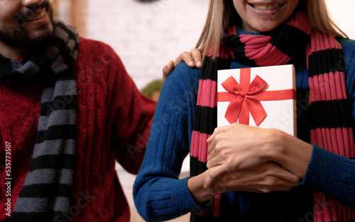 Woman gives her boyfriend a gift box for Christmas day.