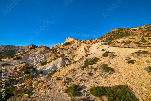 Natural rock formations of yellow cliffs on low sunlight, Milos