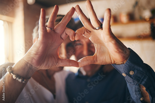 Konstfotografi Love, hands and heart sign with senior couple relax and bonding in their home together, cheerful and in love
