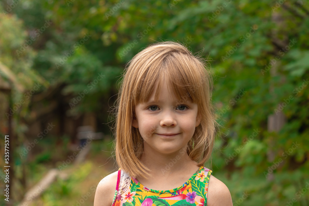 Portrait of a beautiful little girl with blond hair on a background of summer greenery. Portrait of a beautiful little girl with blond hair on a background of summer greenery.