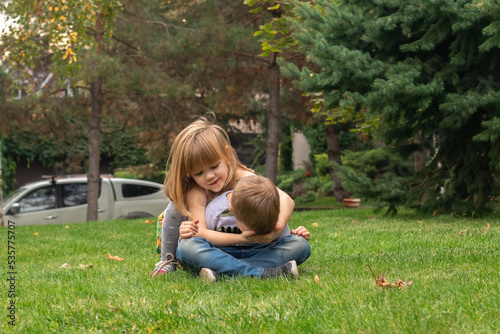 brother and sister playing in the meadow. childhood concept