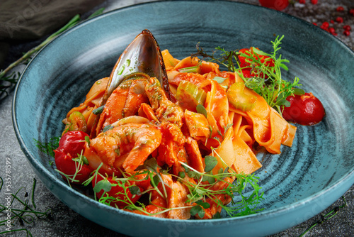 Tagliatelle with seafood, shrimp and oysters in delicate tomato sauce