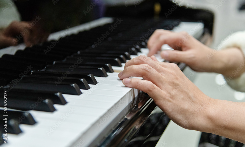 Fototapeta premium Close up of woman hands playing piano