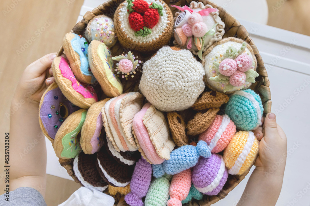 Toy food knitted from yarn. Sweets, pastries, cookies and cakes.