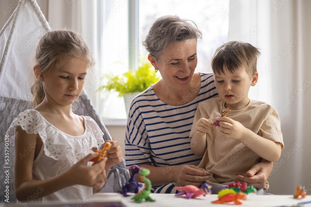 Family mother and kids sculpt dinosaurs from plasticine enjoy weekend Family mother and kids sculpt dinosaurs from plasticine enjoy weekend