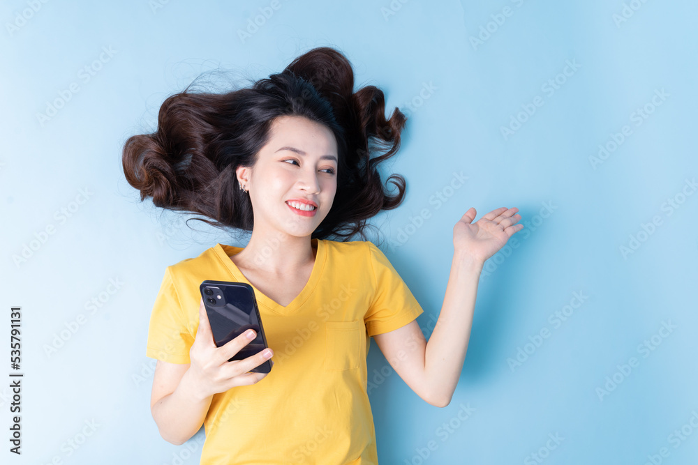 Naklejka premium Image of young Asian woman lying on background
