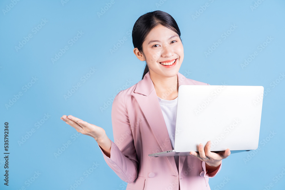 Young Asian business woman using laptop on background Young Asian business woman using laptop on background