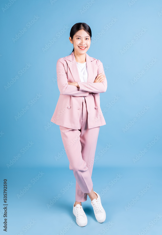 Full length image of young Asian business woman on background Full length image of young Asian business woman on background