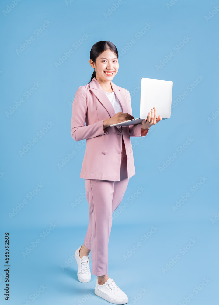 Full length image of young Asian business woman on background Full length image of young Asian business woman on background