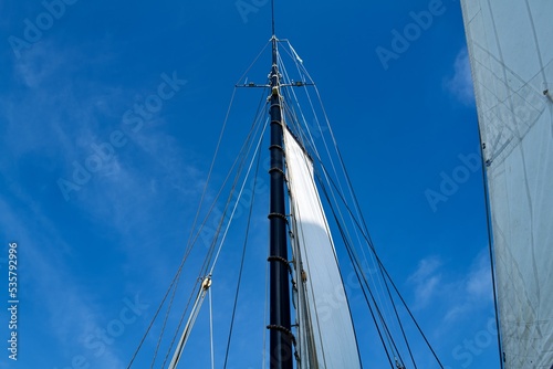 mast of a ship with a white sail