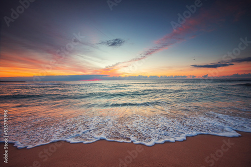 Beach sunrise over the tropical sea waves and beach