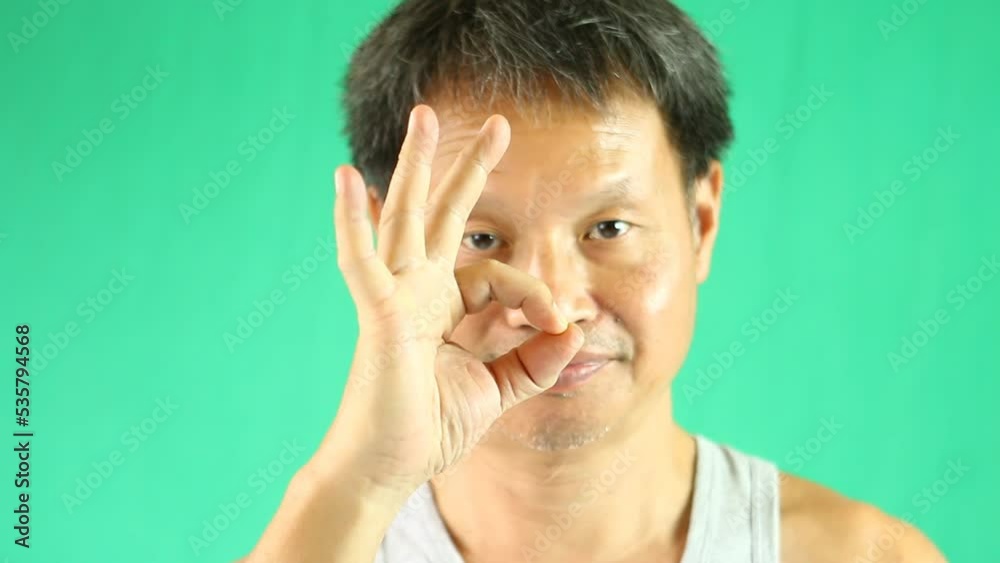 Thai man is showing ok sign , in studio Chiangmai Thailand. Thai man is showing ok sign , in studio Chiangmai Thailand.