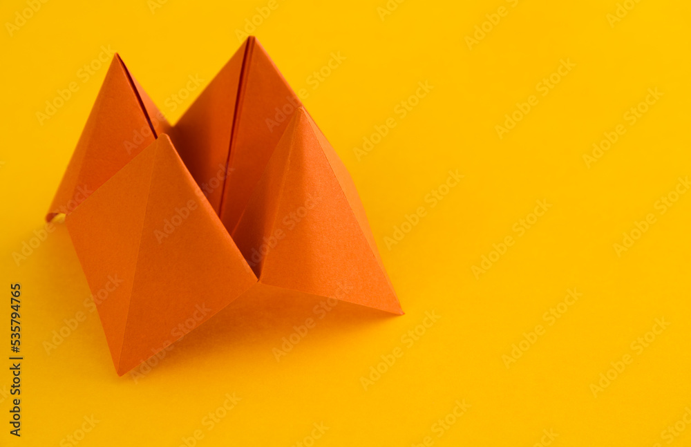 Origami paper fortune on yellow background