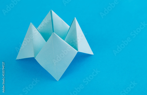 Foto Origami paper fortune on blue background