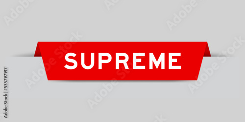 Red color inserted label with word supreme on gray background