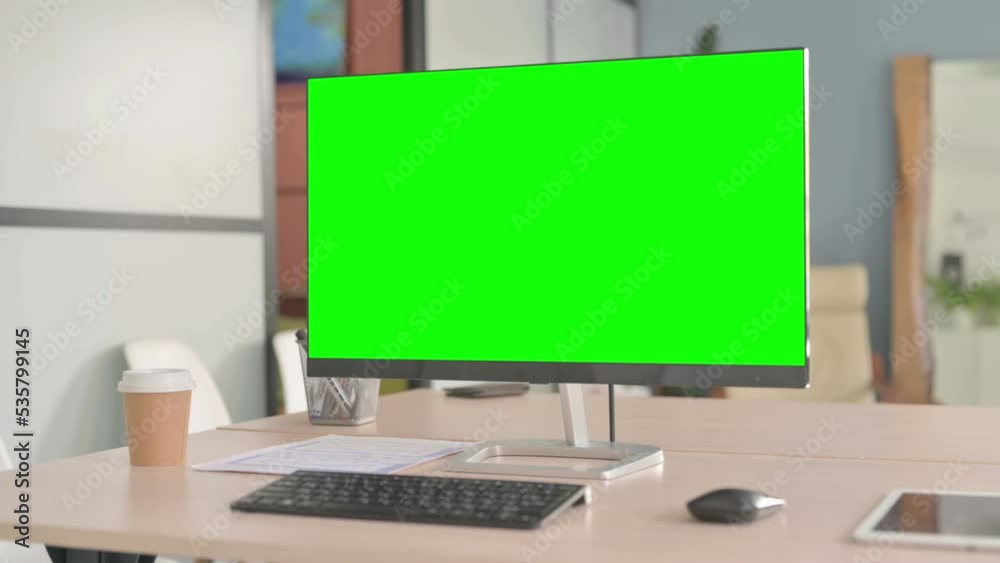 Desktop with Green Screen on Table in Office Desktop with Green Screen on Table in Office