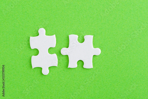 Two puzzle pieces on green background