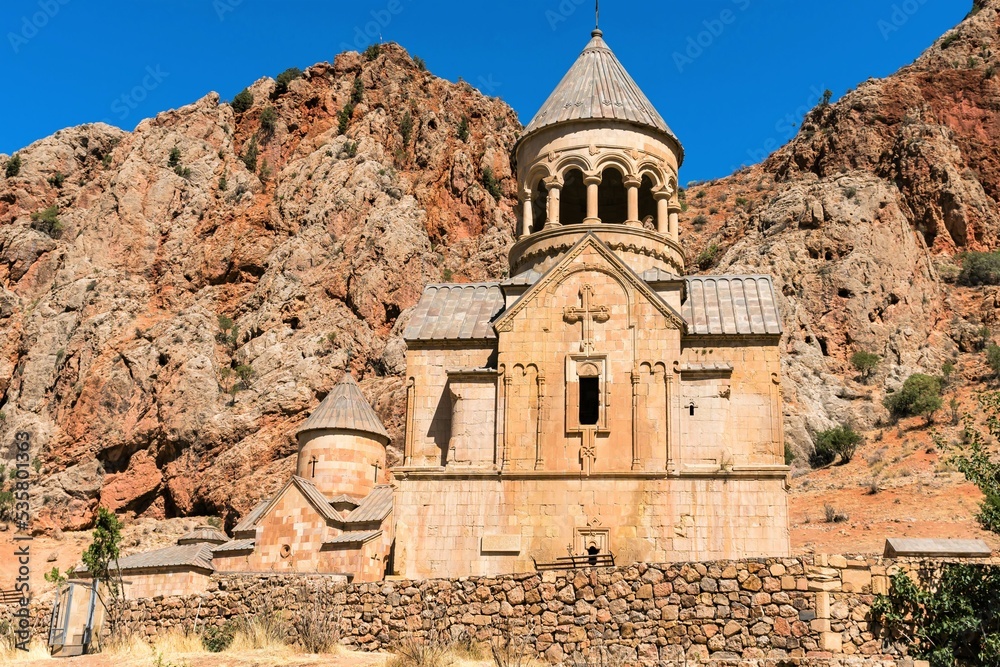 Armenia, Noravank, September 2022. The ancient temple of the monastery against the background of red rocks.
