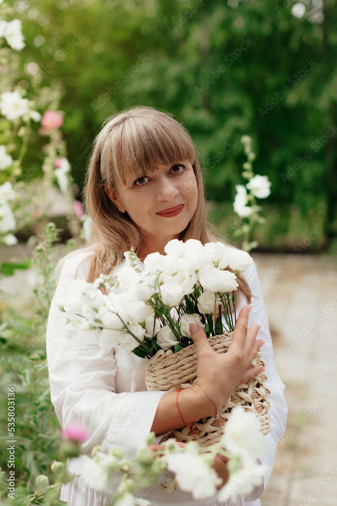 Mid lady feeling good and enjoying freedom at garden, copy space. Beautiful elderly woman in a light clothes. Elderly lifestyle at home concept. Mid lady feeling good and enjoying freedom at garden, copy space. Beautiful elderly woman in a light clothes. Elderly lifestyle at home concept.