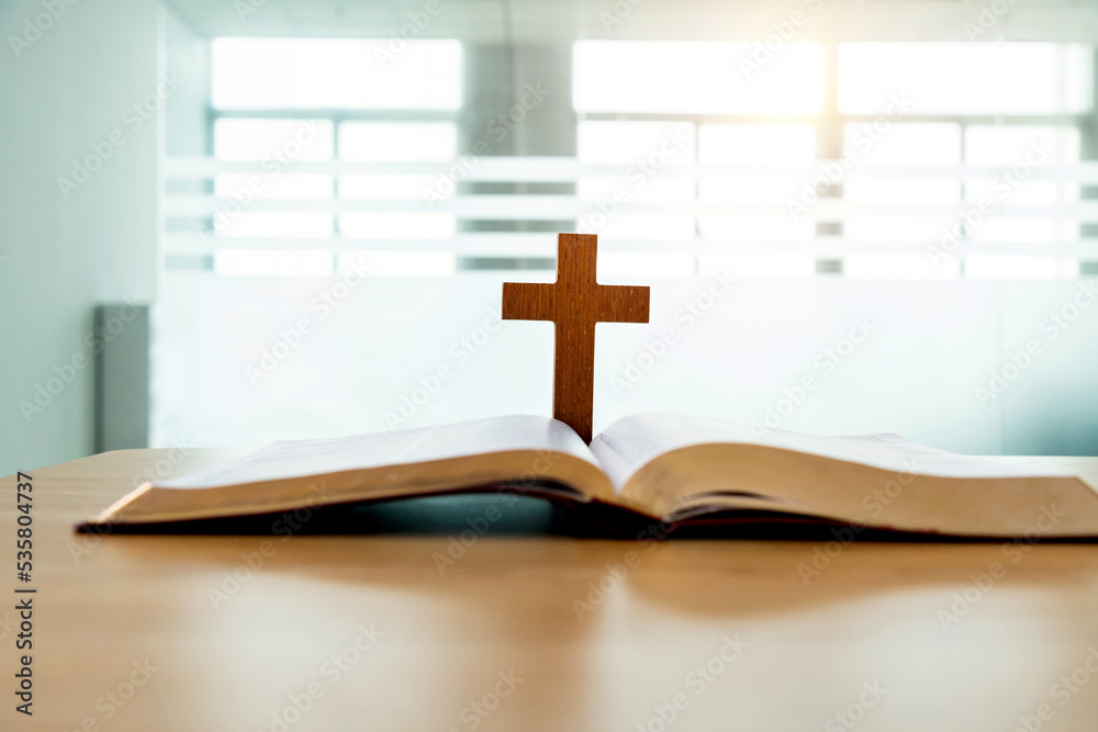 Wooden cross and bible book on the table