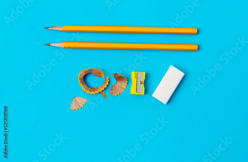 Pencil and pencil sharpener on blue background