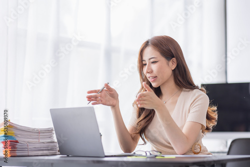 Business Asian woman have business meeting via looking at webcam making conference video call at work copy space in workplace an home office.