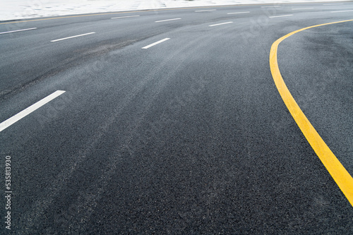 Asphalt road with white stripes and yellow lines