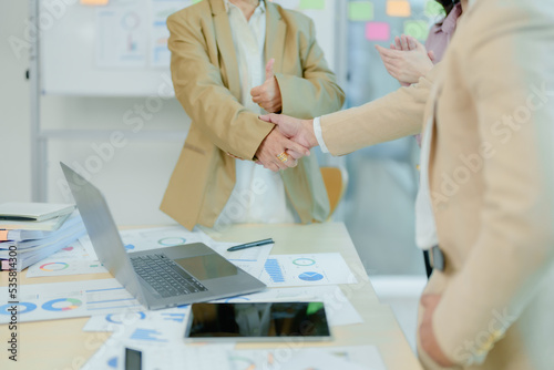 Asian entrepreneurs handshakes to congratulate the agreement between the two companies to enhance investment and financial strength. deal concept