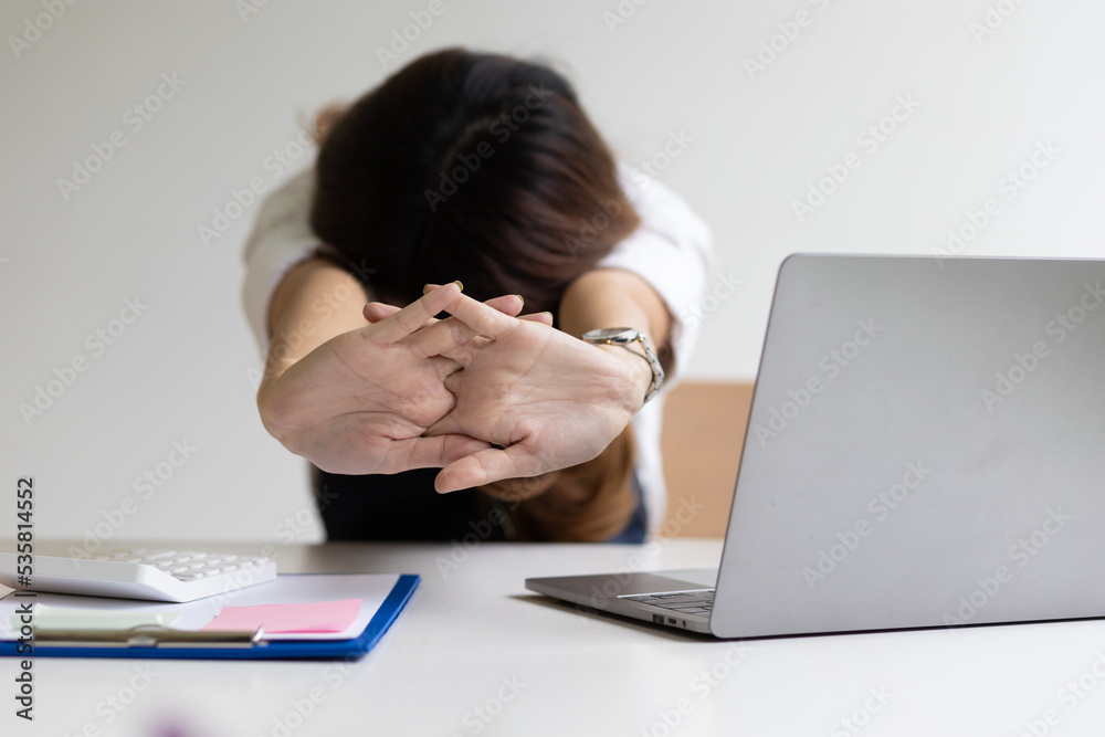 Business woman working in an office stretches to relax from work during breaks.